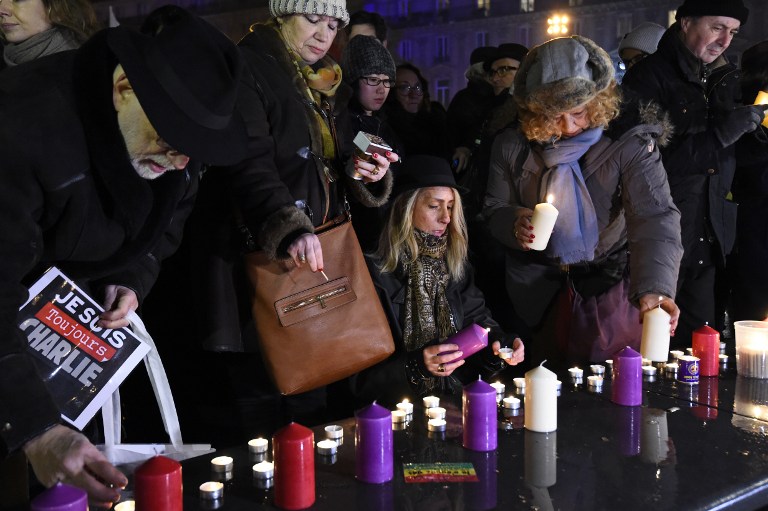 Members of the public light candles during a rally commemorating the second anniversary of the deadly attack against the satirical weekly Charlie Hebdo on January 7, 2017 at the Place de la Republique in Paris. Almost two years after the attacks of January 2015 on French satirical magazine Charlie Hebdo and the Hyper Cacher market, which left 17 people dead and were the first in a series of jihadist attacks in France, investigators are still working to shed light on certain aspects of the events, including the complicity of the killers. / AFP PHOTO / BERTRAND GUAY
