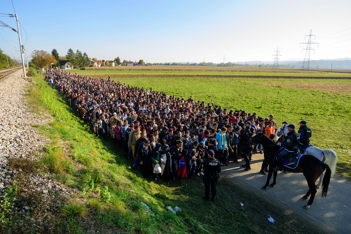 La policía escolta a miles de migrantes y solicitantes de asilo mientras se dirigen a un campo de refugiados tras cruzar la frontera entre Croacia y Eslovenia, cerca de Rigonce, el 24 de octubre de 2015. (AFP / Jure Makovec)