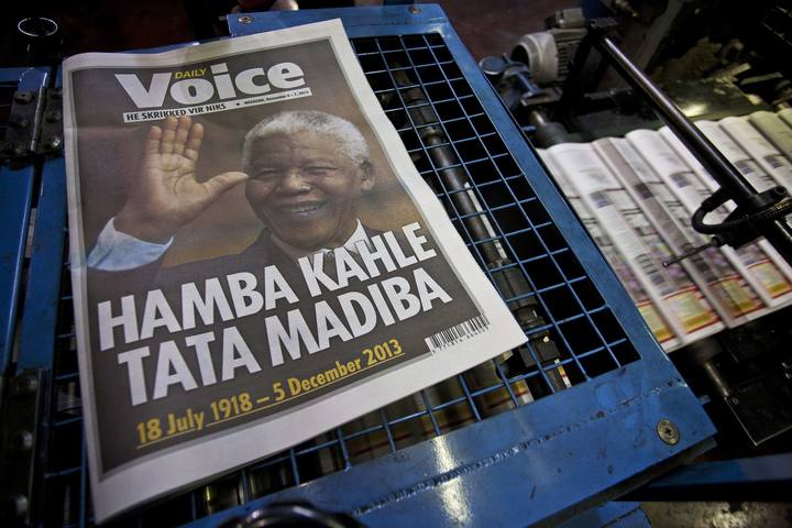 A copy of a newspaper paying tribute to South African President Mandela lies on a printing press as other copies stream through the press in the early hours of the morning in Cape Town
