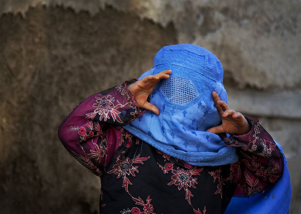 Una niña afgana trata de ver través de los huecos de su burka mientras juega con otros niños en el pueblo de Kabul. Foto: Anja Niedringhaus/Abril 2013